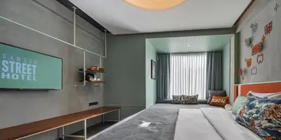 a bedroom with a bed and a flat screen tv at Samsen Street Hotel in Bangkok