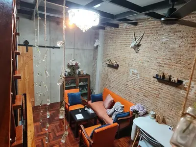 a living room with a couch and a brick wall at MEEMAW'S House Hostel in Bangkok