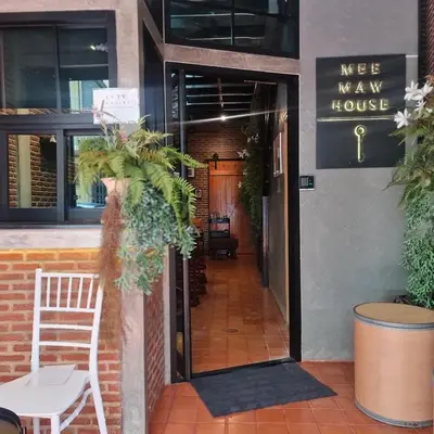 a door to a man house with a chair outside at MEEMAW'S House Hostel in Bangkok