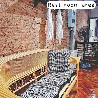 a wooden bench sitting in a room with a brick wall at MEEMAW'S House Hostel in Bangkok
