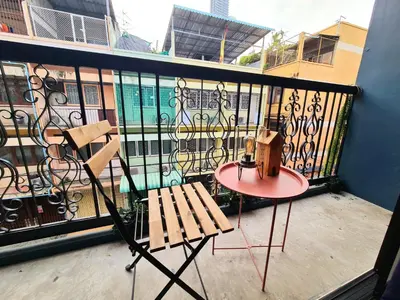 a balcony with a table and a bench on a balcony at MEEMAW'S House Hostel in Bangkok