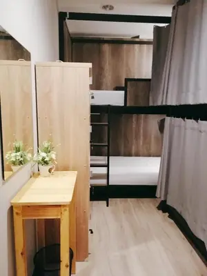 a room with two bunk beds and a table at White House Hostel in Bangkok