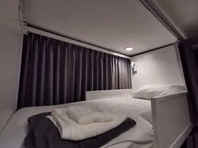 a bedroom with a bed with a towel on it at White House Hostel in Bangkok