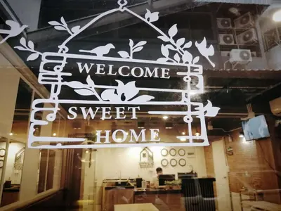 a sign that reads welcome to sweet home in a restaurant at White House Hostel in Bangkok
