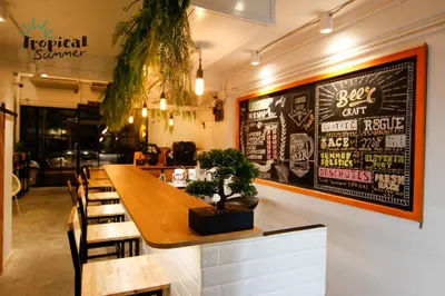 a restaurant with a table and chairs and a chalkboard on the wall at Tropical Summer Hostel in Bangkok