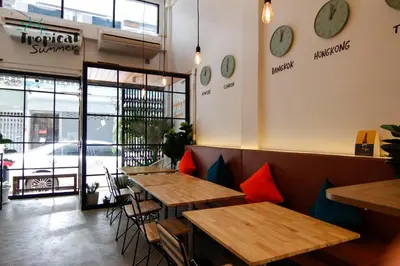 a row of tables in a restaurant with clocks on the wall at Tropical Summer Hostel in Bangkok