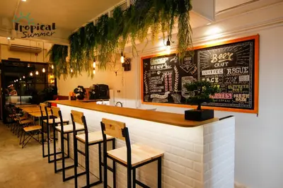 a restaurant with a bar with a bunch of chairs at Tropical Summer Hostel in Bangkok