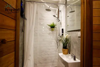 a bathroom with a sink and a shower with plants at Tropical Summer Hostel in Bangkok