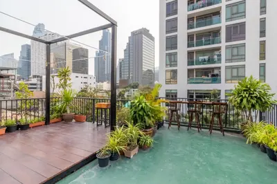 a balcony with a table and chairs on a building at Every Surawong in Bangkok