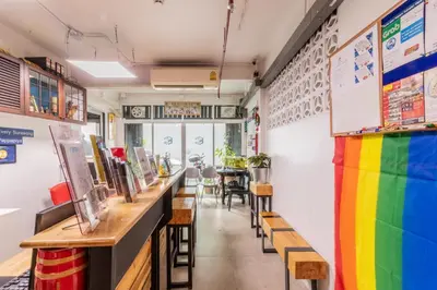 a colorful bar with wooden tables and benches at Every Surawong in Bangkok