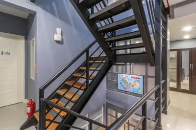 a spiral staircase in a house with a tv on the wall at Every Surawong in Bangkok