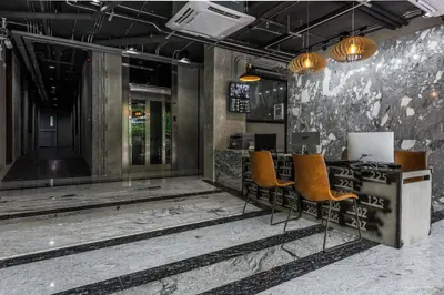a lobby with a desk with orange chairs at Bangkok City Link Hotel in Bangkok