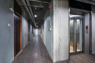 a corridor of an office building with wood floors and walls at Bangkok City Link Hotel in Bangkok