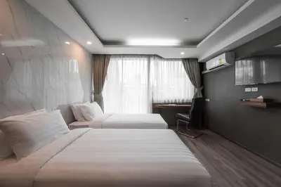 a hotel room with two beds and a desk at Bangkok City Link Hotel in Bangkok