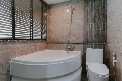 a bathroom with a toilet and a tub and a sink at Bangkok City Link Hotel in Bangkok