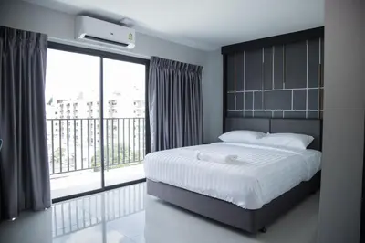 a bedroom with a large bed and a large window at Hallton Hotel Bangkok in Bangkok