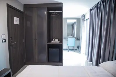 a bedroom with a bed and a walk in closet at Hallton Hotel Bangkok in Bangkok