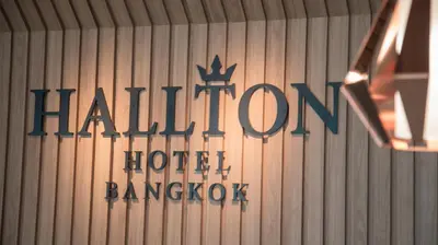 a sign for a hilton hotel bangkok on a wall at Hallton Hotel Bangkok in Bangkok