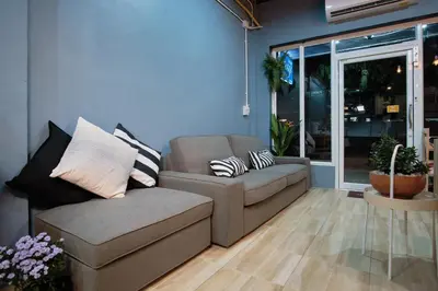 a living room with a couch and a chair at Private Stay Hostel in Bangkok