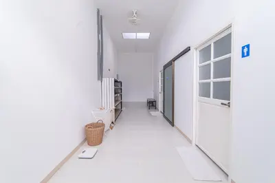 an empty hallway with a door in a room at Napa Hostel Samrong Station in Samutprakarn