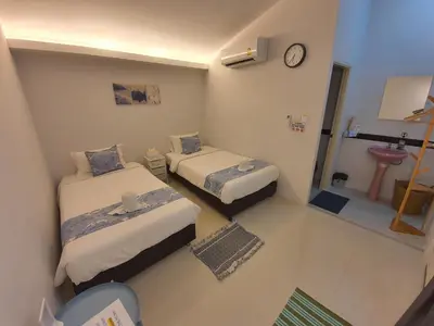 a small room with two beds and a sink at Napa Hostel Samrong Station in Samutprakarn