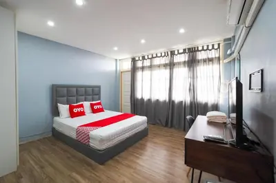 a bedroom with a bed and a desk and a television at Bossa House Hostel & Cafe in Bangkok