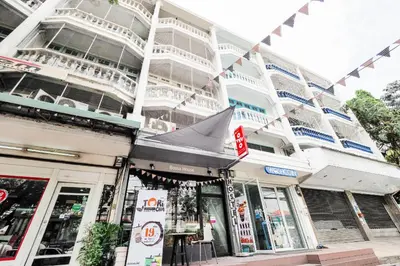 a large white building with flags hanging from it at Bossa House Hostel & Cafe in Bangkok