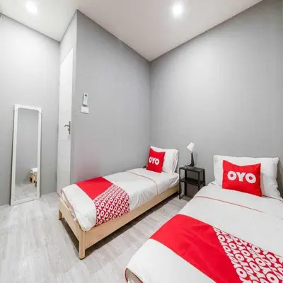 two beds in a room with red and white pillows at Bossa House Hostel & Cafe in Bangkok