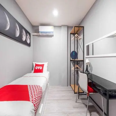 a small bedroom with a bed and a desk at Bossa House Hostel & Cafe in Bangkok