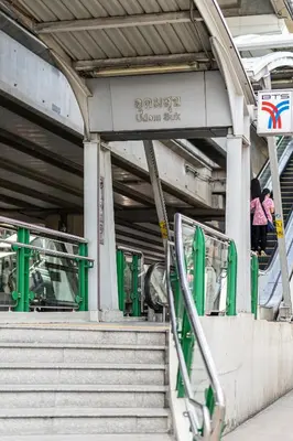 a woman walking up the stairs of a subway station at Udomsuk Inn & Cafe - BTS Udomsuk in Bangkok
