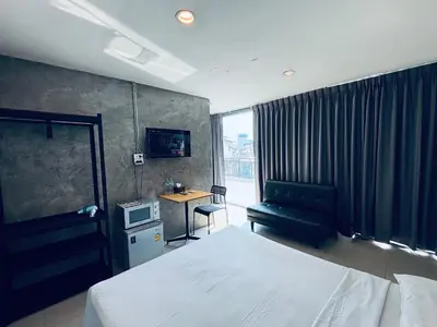 a bedroom with a bed and a couch and a desk at Udomsuk Inn & Cafe - BTS Udomsuk in Bangkok