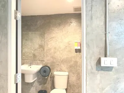 a bathroom with a toilet and a sink at Udomsuk Inn & Cafe - BTS Udomsuk in Bangkok
