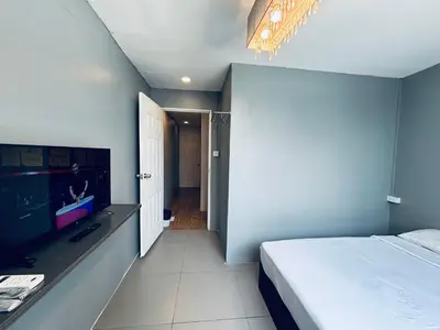 a bedroom with a bed and a flat screen tv at Udomsuk Inn & Cafe - BTS Udomsuk in Bangkok
