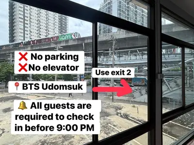 a window with a sign that reads no parking no elevatorbt involuntary required to check at Udomsuk Inn & Cafe - BTS Udomsuk in Bangkok