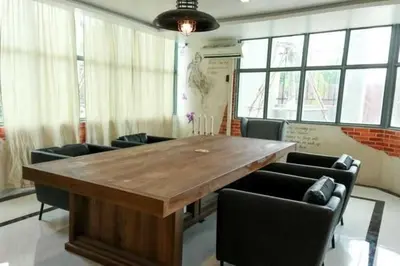 a conference room with a large wooden table and chairs at RQ Bangkok Sukhumvit 107 by Collection O in Samut Prakan