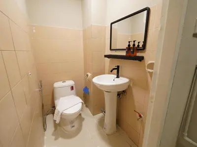 a bathroom with a toilet and a sink and a mirror at RQ Bangkok Sukhumvit 107 by Collection O in Samut Prakan
