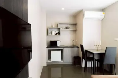 a small kitchen with a table and a microwave at RQ Bangkok Sukhumvit 107 by Collection O in Samut Prakan