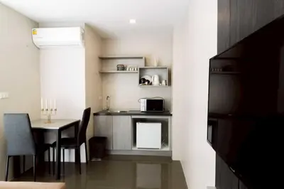 a small kitchen with a table and a microwave at RQ Bangkok Sukhumvit 107 by Collection O in Samut Prakan