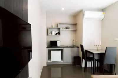 a small kitchen with a table and a microwave at RQ Bangkok Sukhumvit 107 by Collection O in Samut Prakan