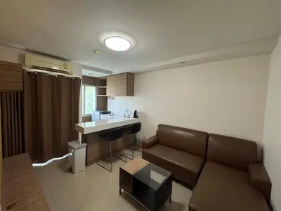 a living room with a couch and a kitchen at Palette Bella B All Suites Bangkok Hotel in Bangkok