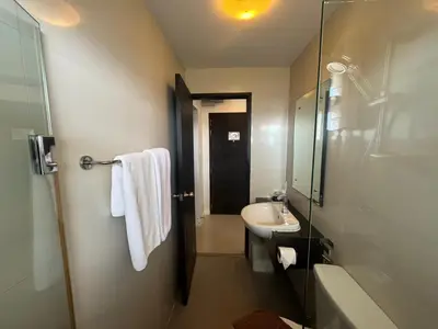 a bathroom with a sink and a toilet and a shower at Palette Bella B All Suites Bangkok Hotel in Bangkok