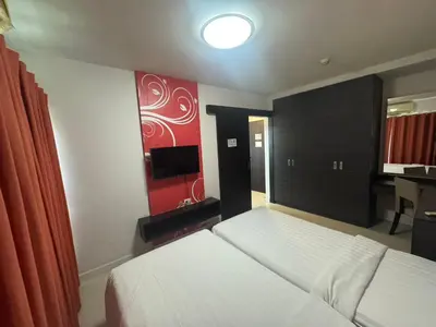 a bedroom with a bed and a flat screen tv at Palette Bella B All Suites Bangkok Hotel in Bangkok
