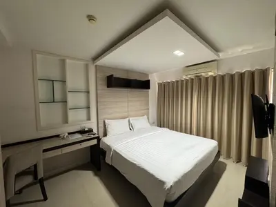 a bedroom with a large white bed and a window at Palette Bella B All Suites Bangkok Hotel in Bangkok
