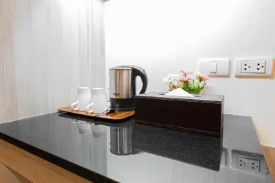 a kitchen counter with a coffee maker on a counter top at Leela Orchid Hotel in Bangkok