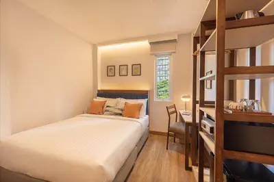 a bedroom with a bunk bed and a desk at SOVA Hotel Bangkok in Bangkok