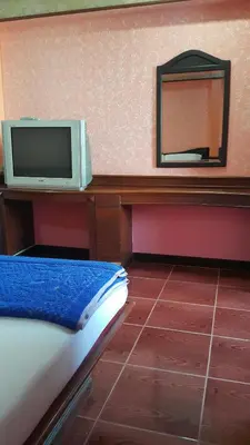 a room with a tv on a desk with a mirror at West Wing Mansion in Bangkok