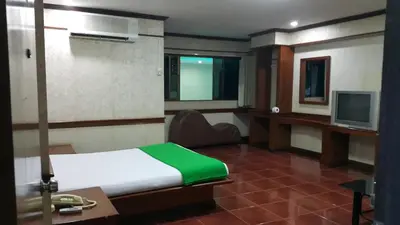 a bedroom with a bed and a desk and a television at West Wing Mansion in Bangkok