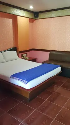 a bedroom with a large bed with a blue blanket at West Wing Mansion in Bangkok