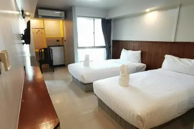 a hotel room with two beds with white sheets at A Sleep Bangkok Sathorn in Bangkok