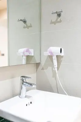 a bathroom with a white sink and a mirror at A Sleep Bangkok Sathorn in Bangkok